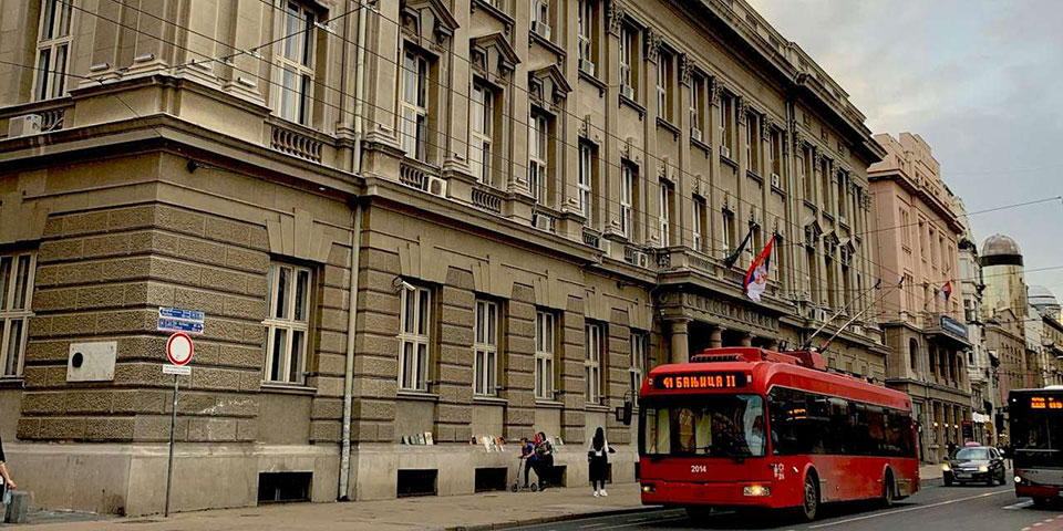Zgrada fakulteta u Beogradu ispred koje prolazi crvena trola