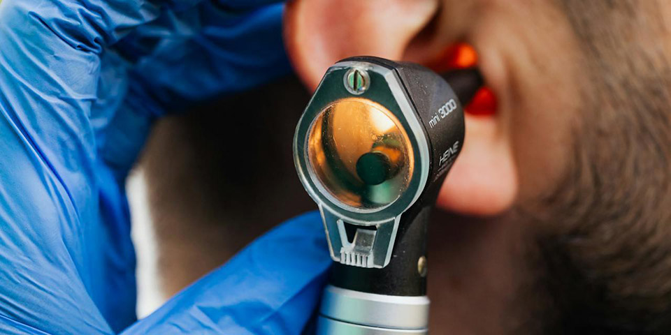 Doktor pregleda uho pacijentu