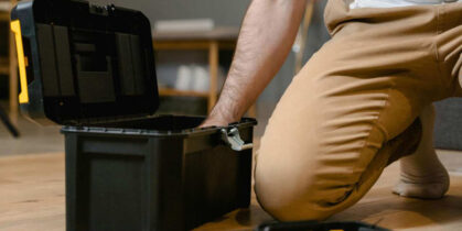 Čovek uzima alat iz kutije sa alatima