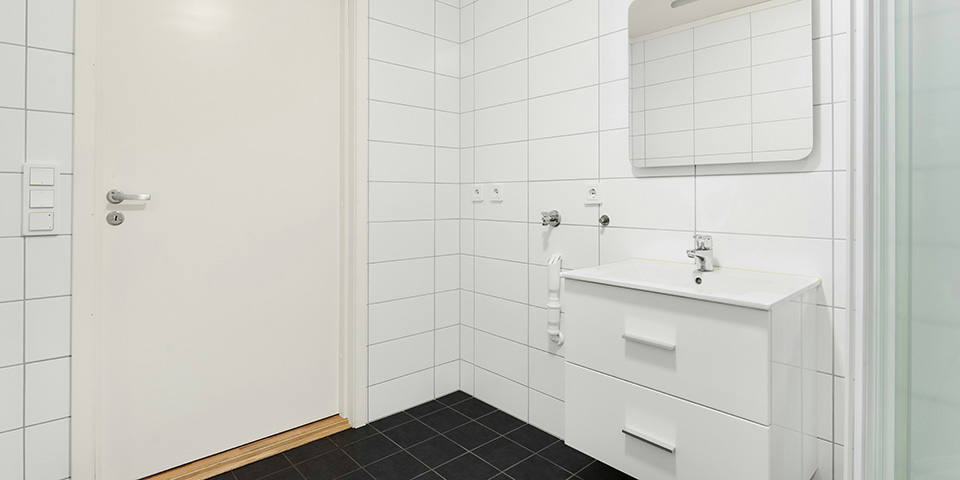 Svetlo kupatilo sa ogledalom, kompaktni lavabo i donjim ormarićem