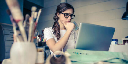 Žena razmišlja dok radi na laptopu