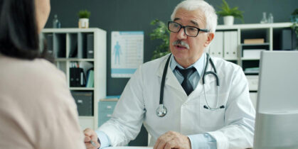 zdravstveni radnik meri krvni pritisak ženi u ordinaciji