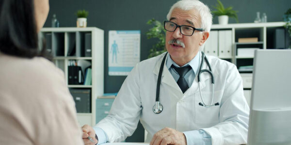 zdravstveni radnik meri krvni pritisak ženi u ordinaciji