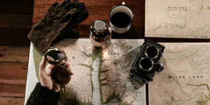 Jedna ruka drži kompas dok druga pokazuje lokaciju na karti