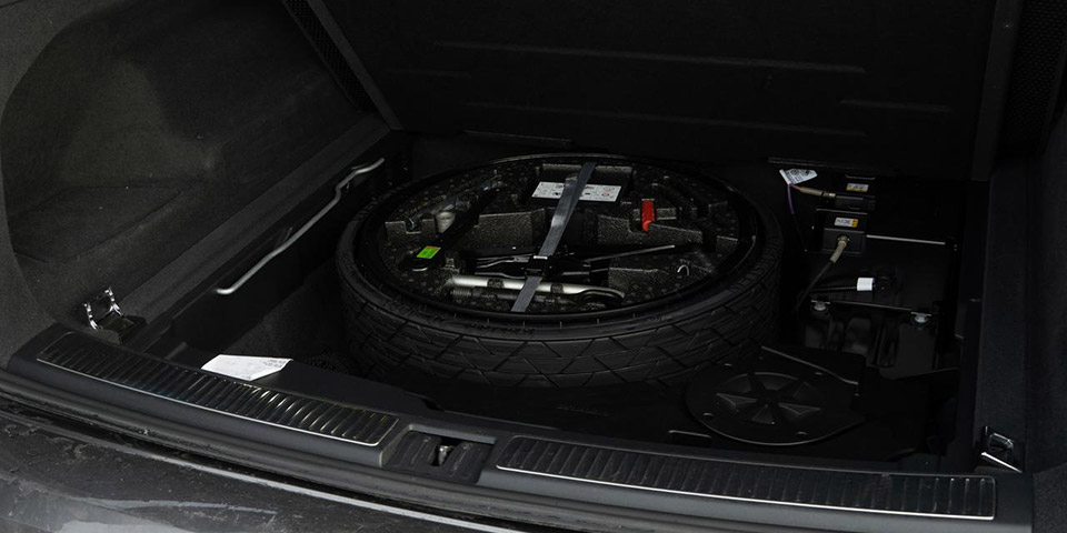 Rezervni točak sa alatkama u otvorenom prtljažniku automobila